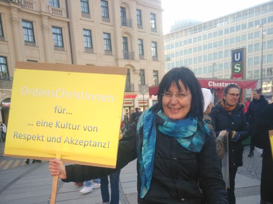 Susanne Schneider hält ein Plakat hoch: „OrdensChristinnen für eine Kultur von Respekt und Akzeptanz!”