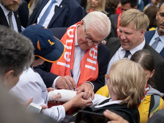 Bundespräsident Frank-Walter Steinmeier (M) unterschreibt während eines Rundgangs beim Katholikentag auf dem Gips eines Mädchens. +++ dpa-Bildfunk +++