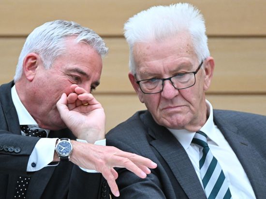 Thomas Strobl (l, CDU), Innenminister von Baden-Württemberg und Winfried Kretschmann (Bündnis 90/Die Grünen), Ministerpräsident von Baden-Württemberg unterhalten sich auf der Regierungsbank bei einer Plenardebatte im Landtag. Strobl gilt als Brückenbauer zu den Grünen und Kretschmann, das Verhältnis der beiden Männer gilt als Kitt der Koalition im Südwesten. (zu dpa: «Strobl über Kretschmann: «Wir bescheißen uns nicht gegenseitig») +++ dpa-Bildfunk +++