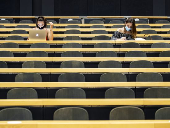 Studentinnen mit Mund-Nasen-Schutz sitzen in einem Hörsaal der Universität Zürich (UZH) am Tag der Rückkehr der Studenten an die Universität nach der Sommerpause.