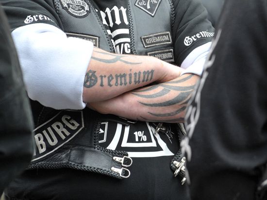 Mit einem Tattoo mit der Aufschrift "Gremium" auf dem Arm steht am Freitag (25.03.2011) vor dem Landgericht in Oldenburg ein Mitglied eines Motorradclubs in der Menge. Der Prozess gegen drei Mitglieder des Clubs wegen versuchten Totschlags begann unter strengen Sicherheitsvorkehrungen. Foto: Carmen Jaspersen dpa/lni ++ +++ dpa-Bildfunk +++