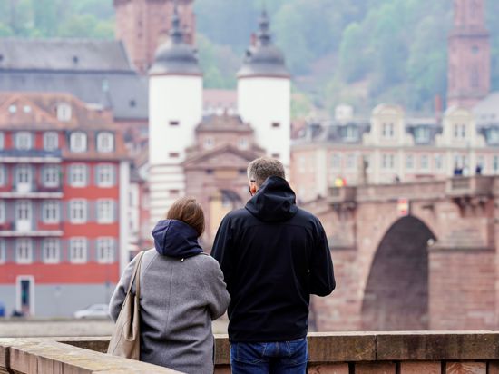 Ein Mann und eine Frau stehen an der Alten Brücke. Heidelberg kann als erste Stadt im Südwesten die Bundesnotbremse lockern. In fast allen Land- und Stadtkreisen Baden-Württemberg gelten derzeit noch die verschärften Regelungen des Bundes. +++ dpa-Bildfunk +++