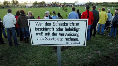 Schild vor einem Fußballplatz: „Wer den Schiedsrichter beschimpft und beleidigt, muß mit dem Verweis vom Sportplatz rechnen“