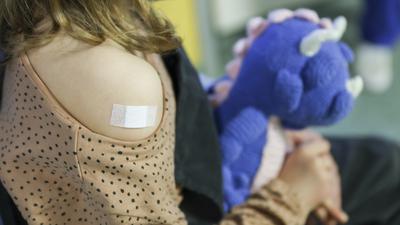 Ein Pflaster klebt auf den Arm eines 7-jähriges Mädchens, nachdem es gegen das Covid19-Virus geimpft wurde. 