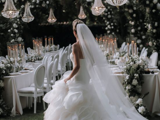 Braut vor einem Tisch unter Bäumen