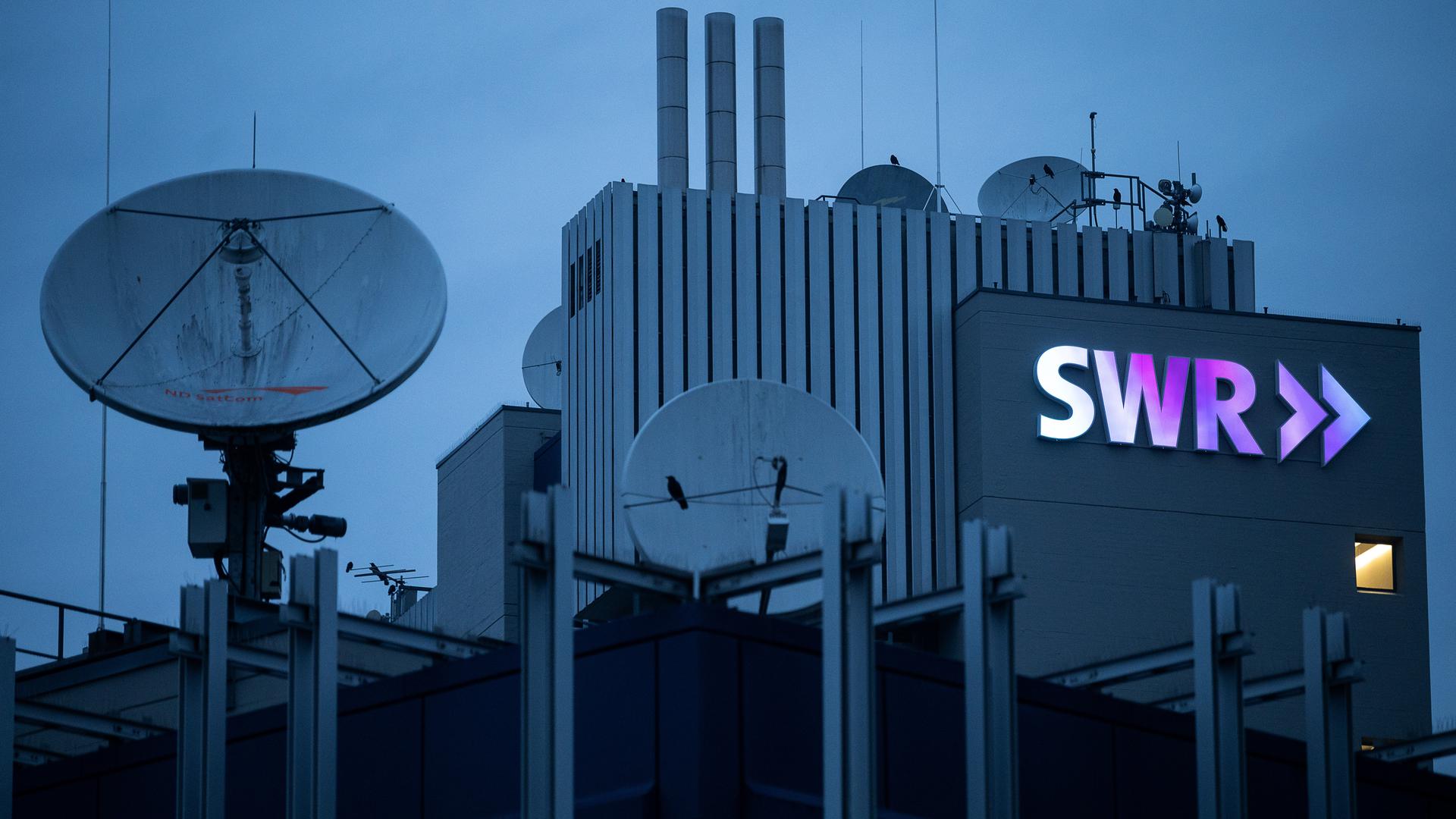 Das Logo des Südwestrundfunks (SWR) leuchtet am frühen Morgen am Funkhaus. Am 5. Februar 2021 findet die Online-Jahrespressekonferenz des Südwestrundfunks statt. +++ dpa-Bildfunk +++