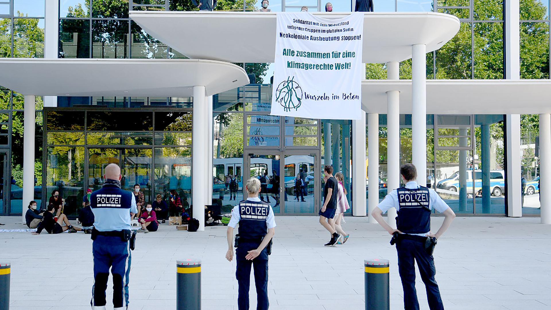 Eine Gruppe von Klimaaktivisten protestiert mit einem Transparent vor der Zentrale des Zementherstellers HeidelbergCement.