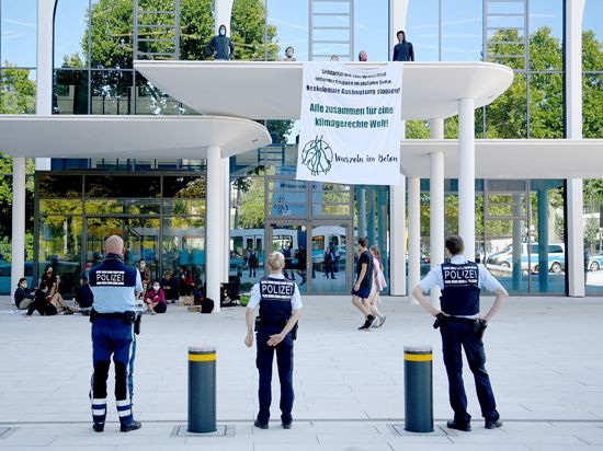 Eine Gruppe von Klimaaktivisten protestiert mit einem Transparent vor der Zentrale des Zementherstellers HeidelbergCement.