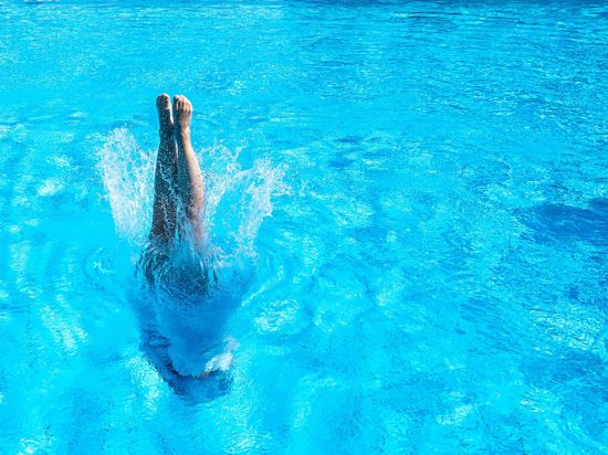Eine Frau taucht in einem Stuttgarter Schwimmbad ins Becken ein.