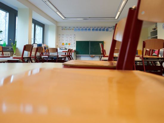 In einem Klassenzimmer sind die Stühle auf die Tische gestellt.