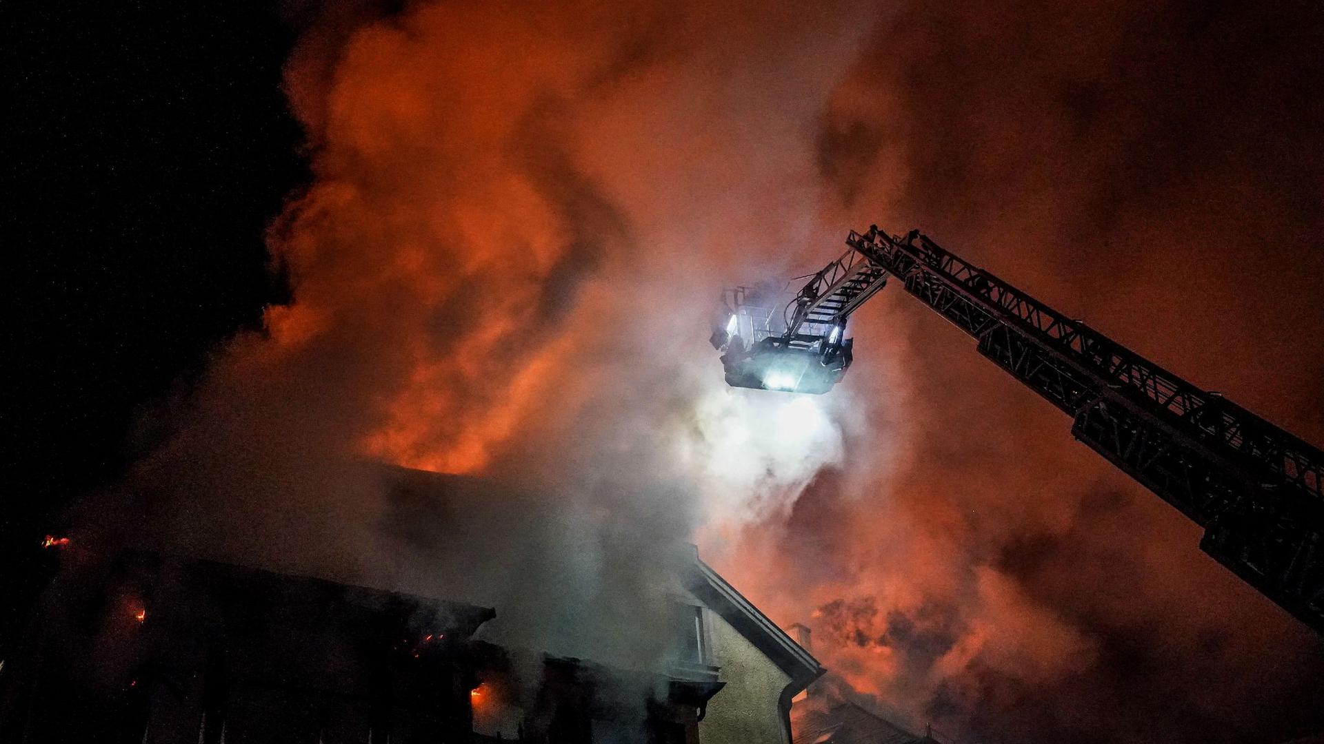 Feuerwehrleute bekämpfen einen Dachstuhlbrand.