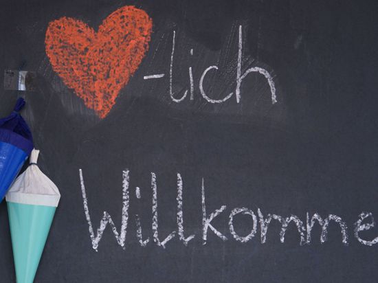 "Herzlich Willkommen“ steht zu Beginn des neuen Schuljahrs mit Kreide auf der Tafel eines Klassenzimmers.