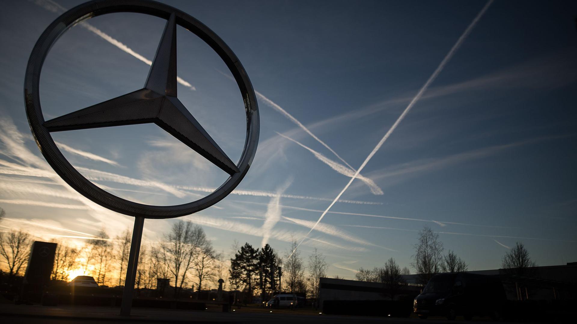 Die Sonne geht hinter einem Mercedes-Stern auf dem Mercedes-Benz-Werk auf.