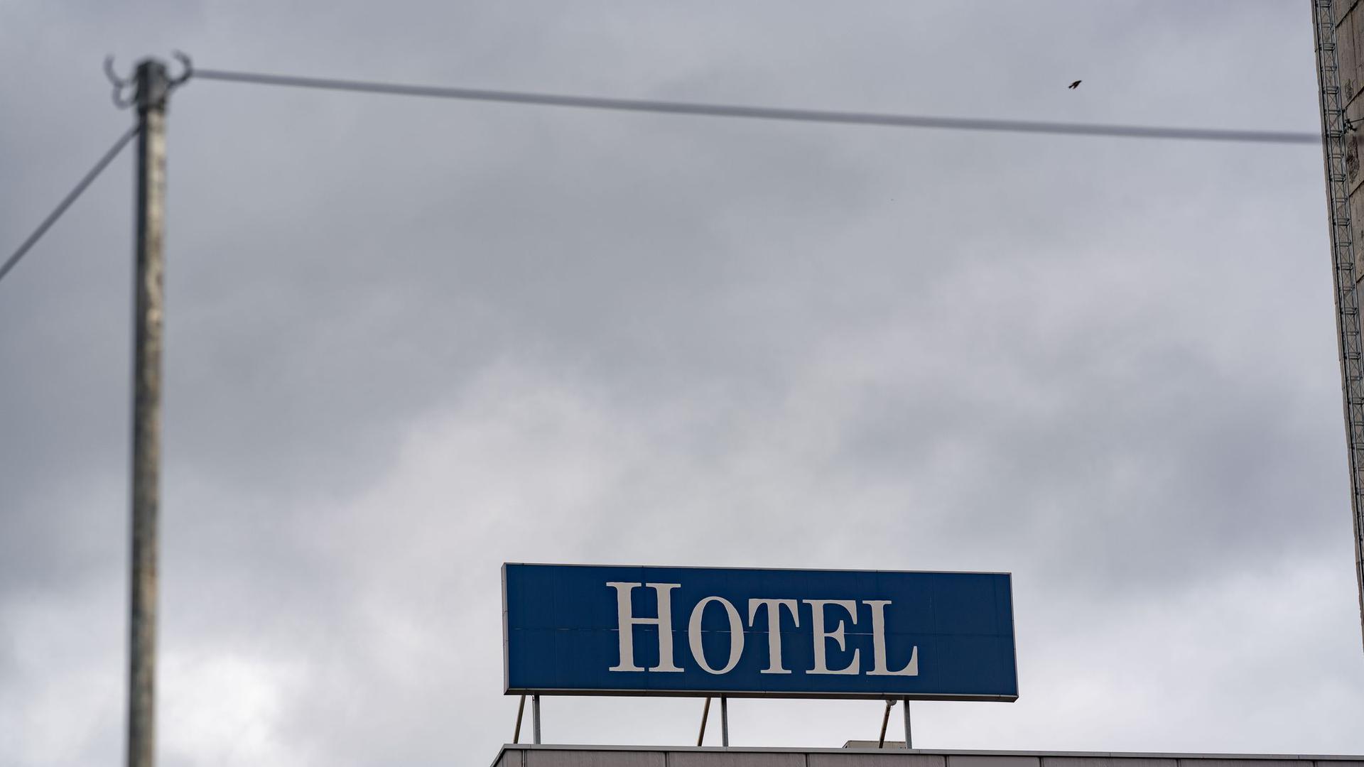 Das Wort „Hotel“ steht auf einer Leuchttafel auf einem Hotel.