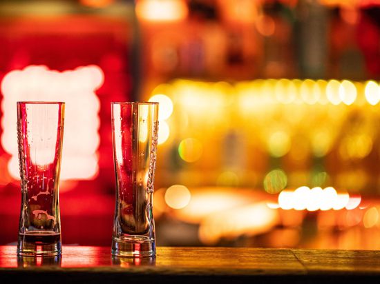 Zwei leere Gläser stehen auf einem Tresen in einer Bar.