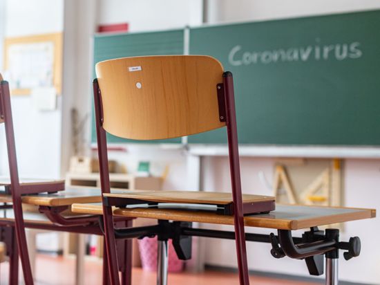 „Coronavirus“ steht auf einer Tafel in einem leeren Klassenzimmer.