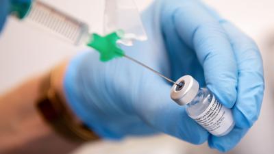 Eine Klinikmitarbeiterin bereitet den Corona-Impfstoff von Biontech/Pfizer zur Impfung vor.