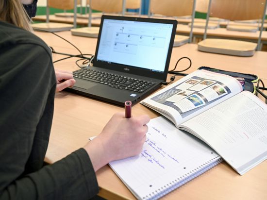 Eine Schülerin lernt während der Notbetreuung im Klassenzimmer am Laptop.