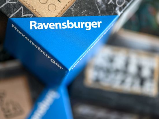 Spiele der Marke Ravensburger liegen übereinander auf einem Tisch.