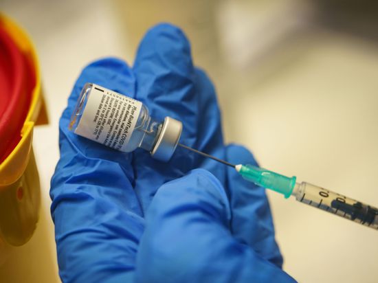 Ein Arzt bereitet eine Dosis mit dem Impfstoff von Biontech/Pfizer für eine Impfung vor.