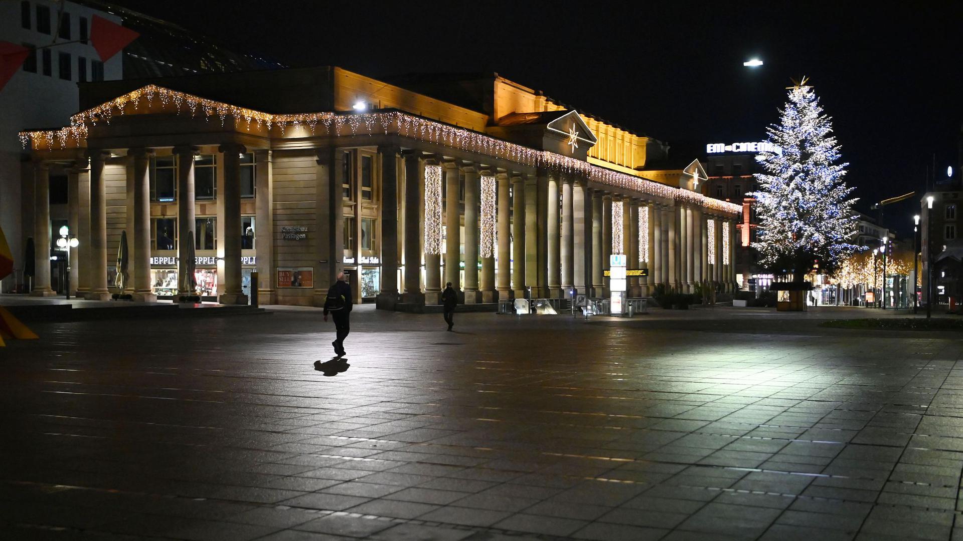 Ab Donnerstag wieder in einigen Teilen des Landes erlaubt: Zwei Personen gehen nachts über den Stuttgarter Schlossplatz.