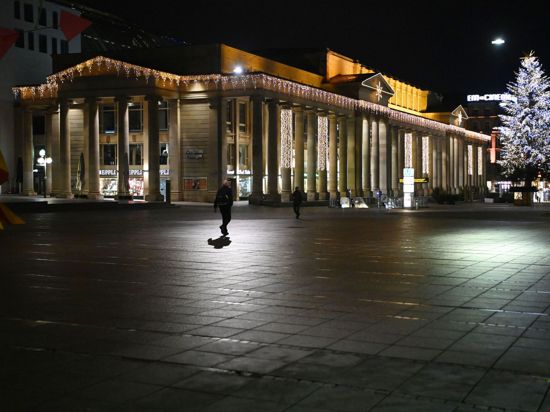 Ab Donnerstag wieder in einigen Teilen des Landes erlaubt: Zwei Personen gehen nachts über den Stuttgarter Schlossplatz.