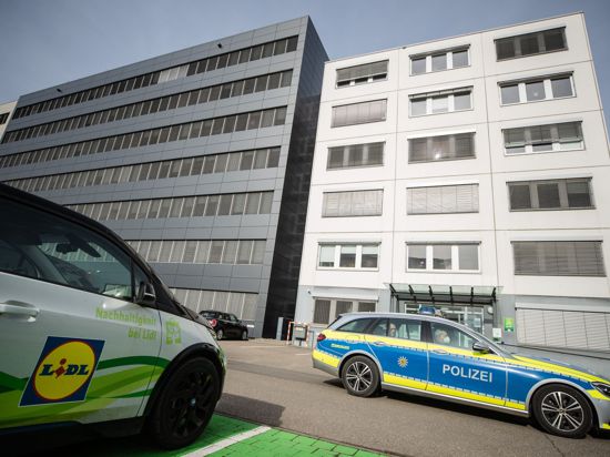 Ein Fahrzeug der Polizei fährt an der Lidl Zentrale in Neckarsulm vorbei.