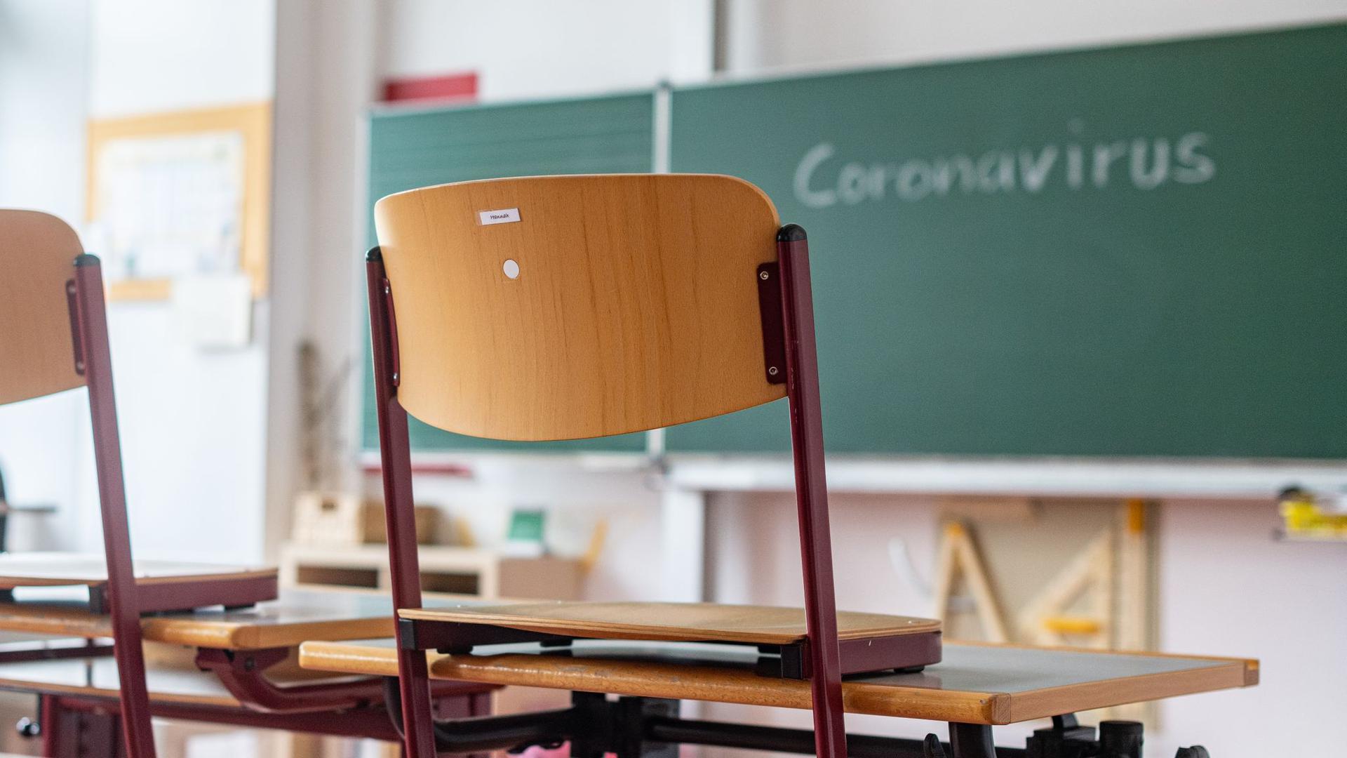 „Coronavirus“ steht auf einer Tafel in einem leeren Klassenzimmer.