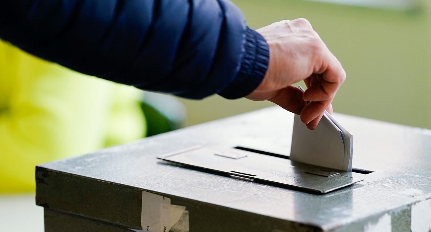 Ein Wählerin wirft in einem Wahllokal ihren Stimmzettel in die Wahlurne.