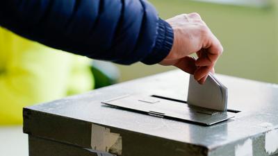 Ein Wählerin wirft in einem Wahllokal ihren Stimmzettel in die Wahlurne.