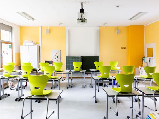 Stühle stehen auf Tischen in einem leeren Klassenzimmer einer Realschule.