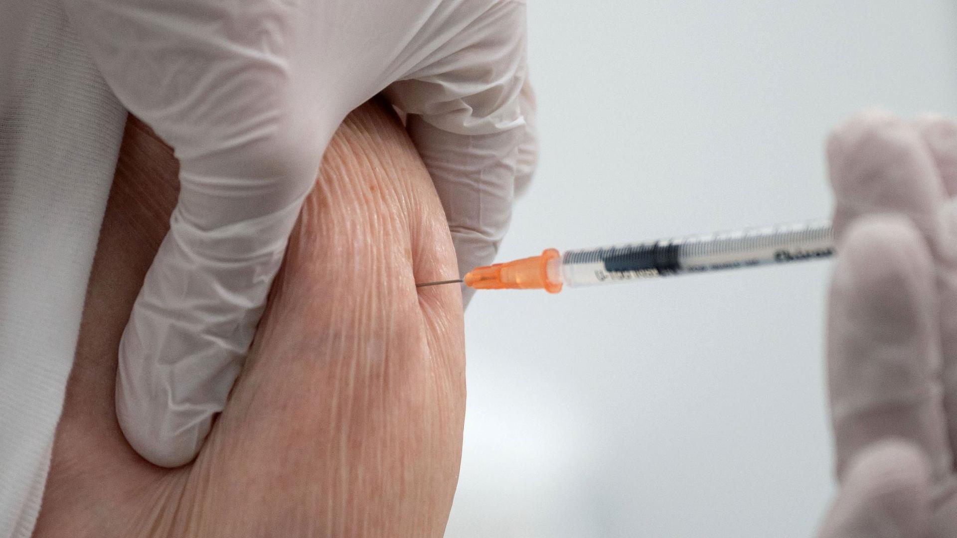 Eine Krankenschwester impft im Impfzentrum in der Paul-Horn-Arena in Tübingen eine Frau.