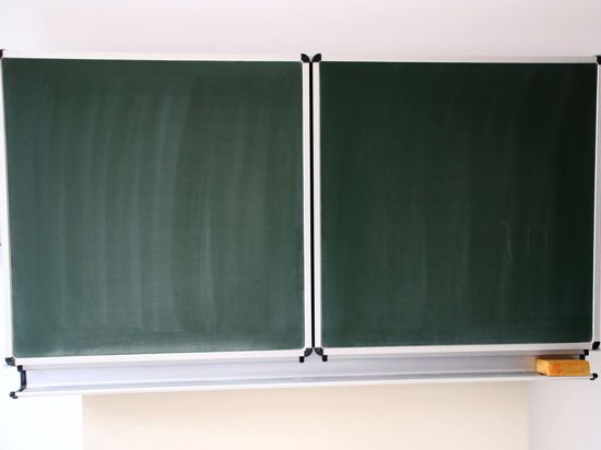 Eine Schultafel steht in einem Klassenzimmer in einer Schule.