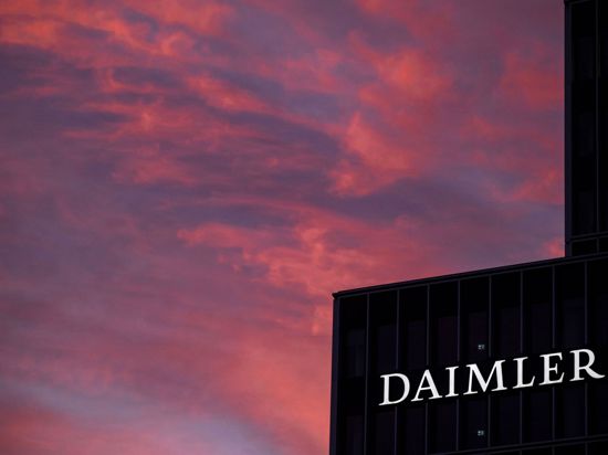 Das Logo der Daimler AG ist in der Morgendämmerung auf der Zentrale des Autokonzerns zu sehen.