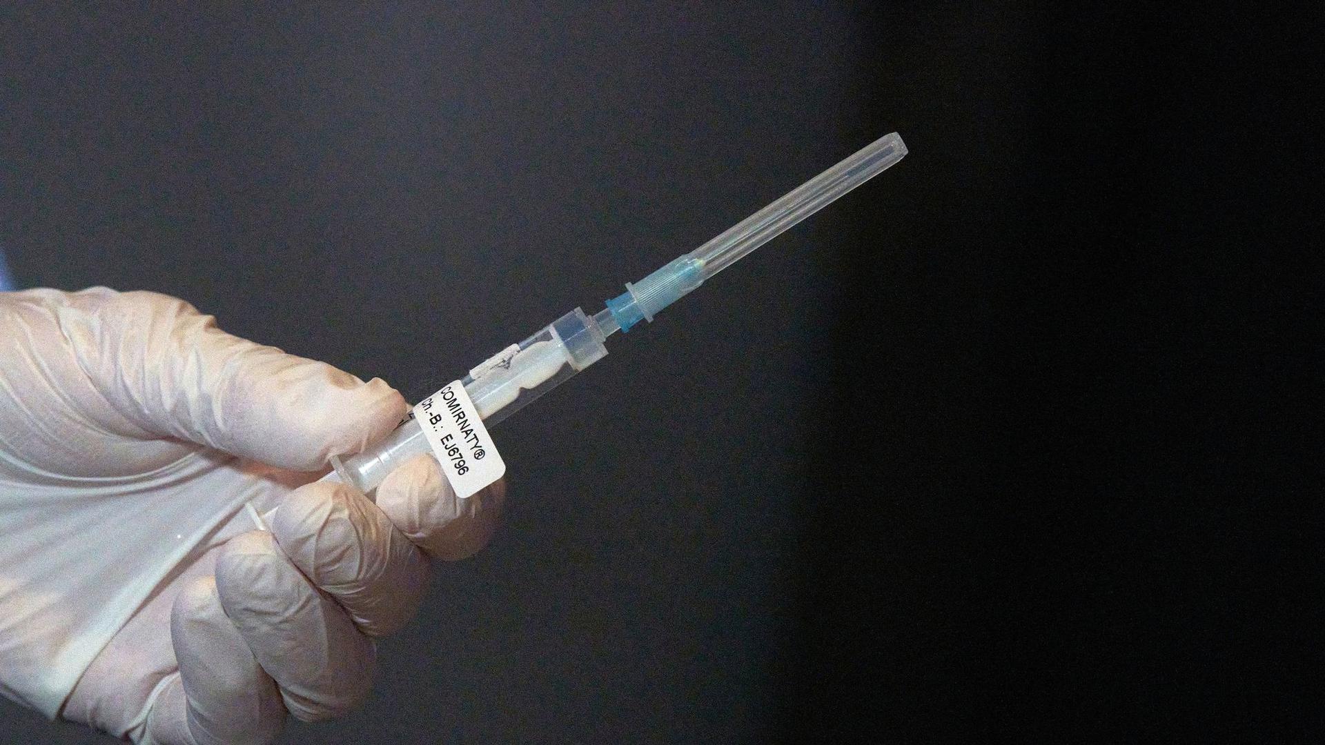 Eine Mitarbeiterin des Impfteams überprüft eine Spritze.