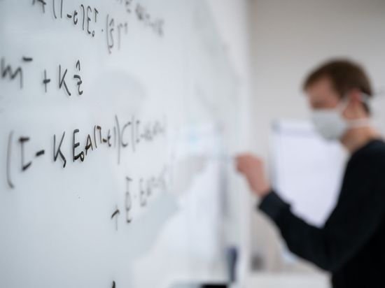 Mathematische Formeln werden in der Universität Tübingen an ein Whiteboard geschrieben.