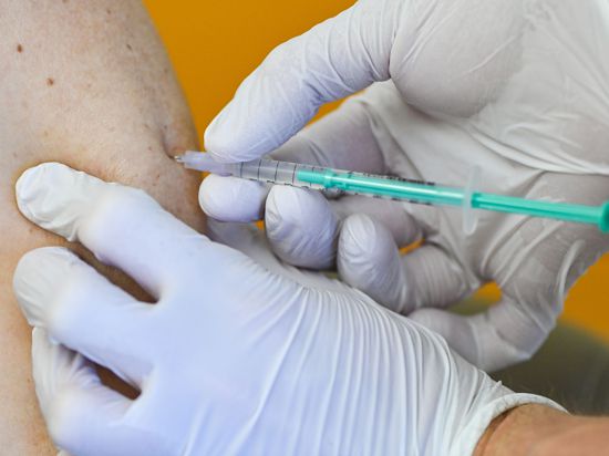 In einer Hausarztpraxis bekommt ein Mann seine Erstimpfung gegen das Coronavirus.