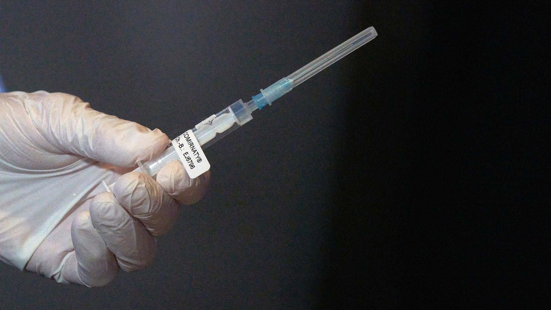 Eine Mitarbeiterin des Impfteams überprüft eine Spritze.