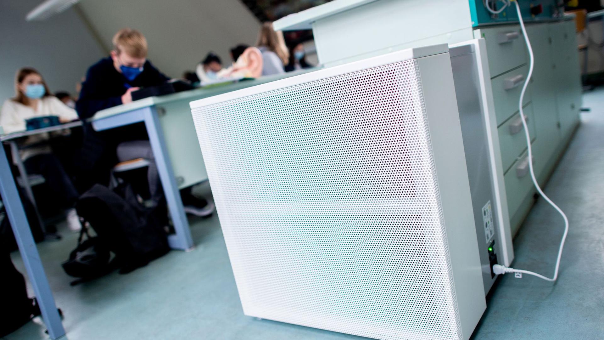 Ein Luftfiltergerät steht in einem Klassenraum.