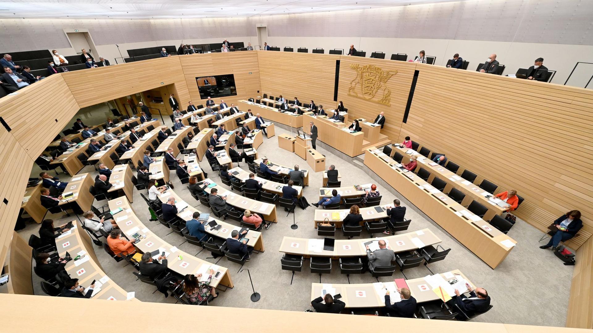 Abgeordnete sitzen im Plenarsaal des Landtags von Baden-Württemberg.