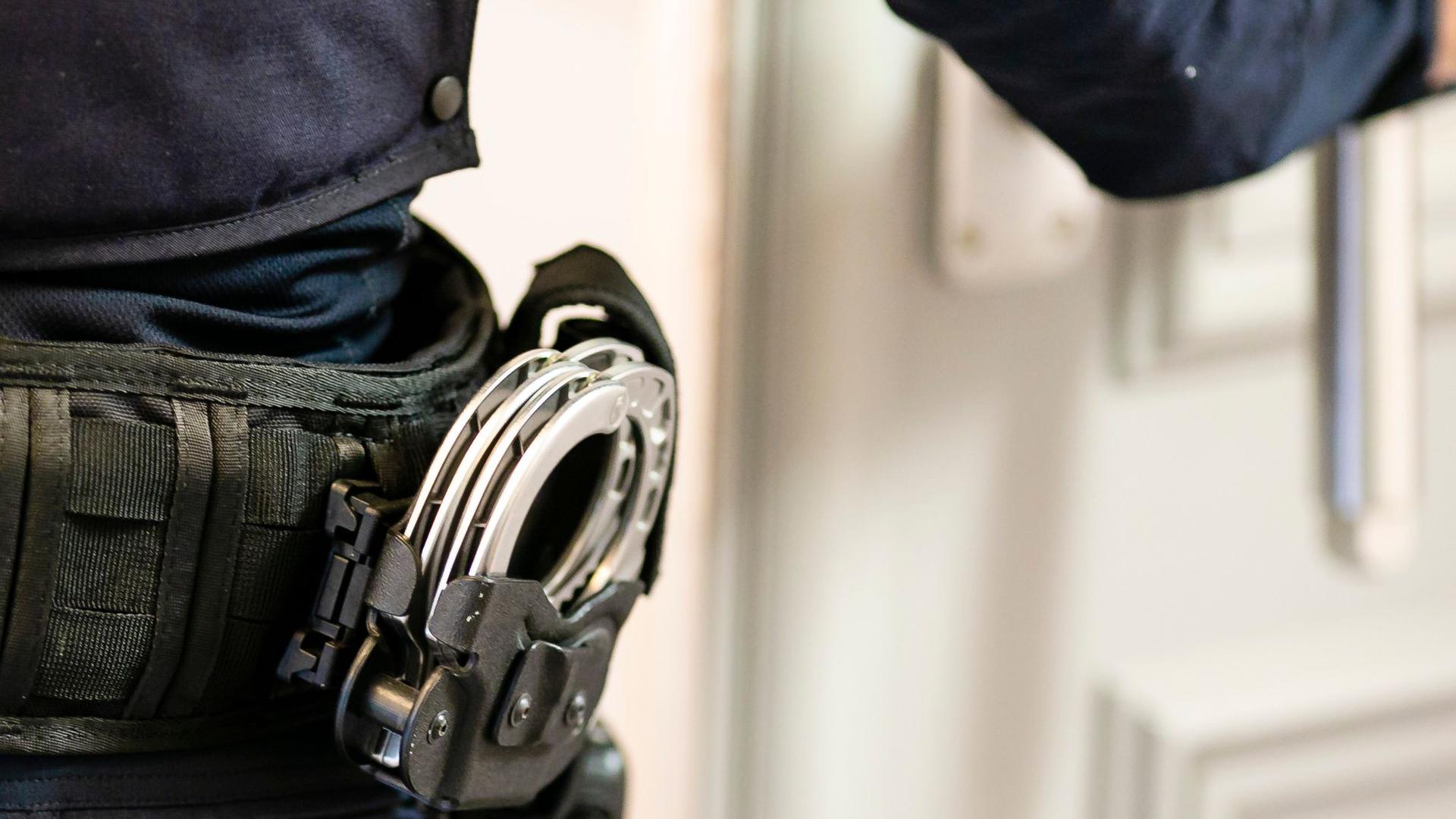 Handschellen sind an einem Gürtel eines Justizvollzugsbeamten befestigt.