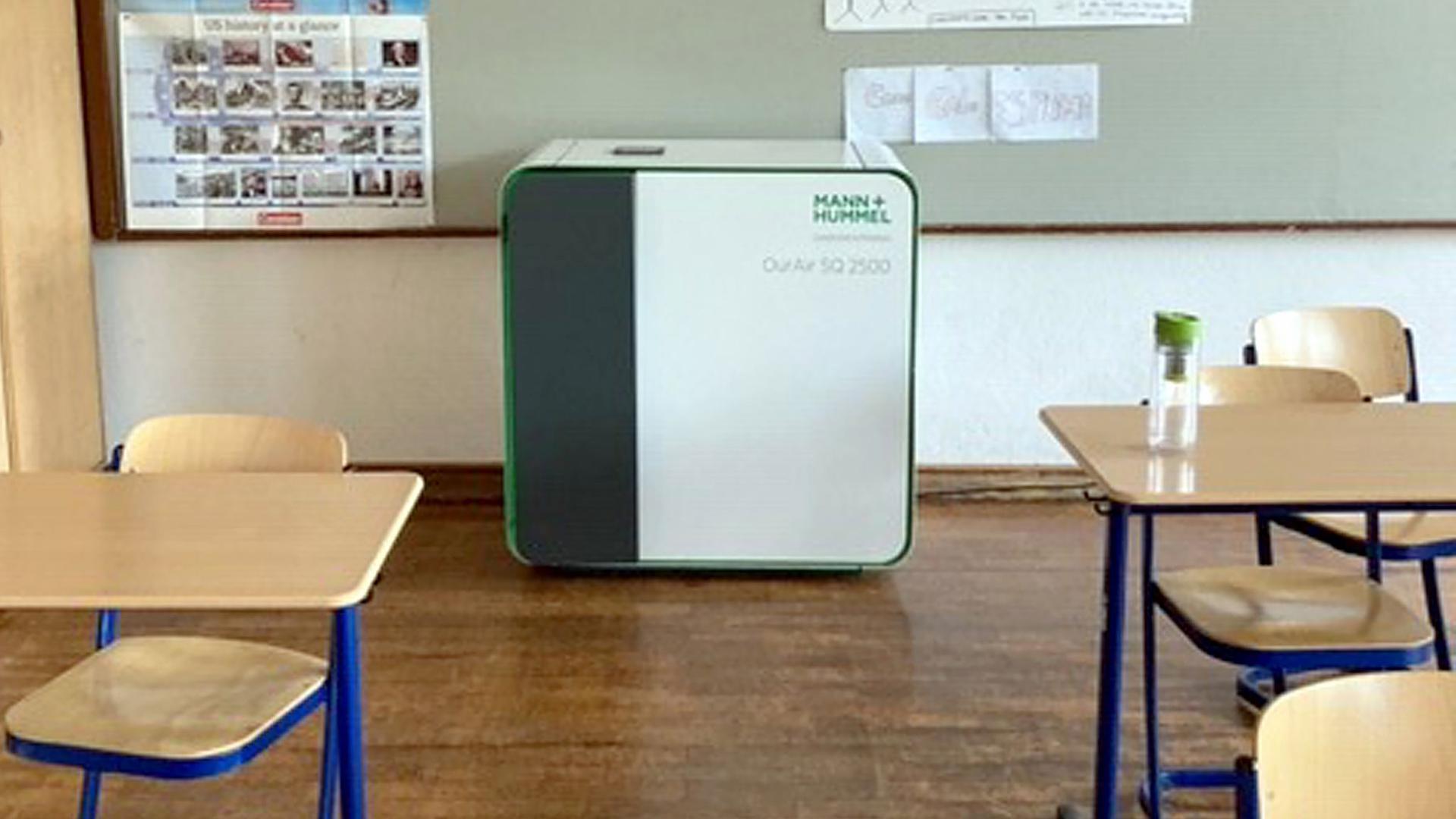 Ein mobiles Luftfiltergerät steht in einem Klassenzimmer.