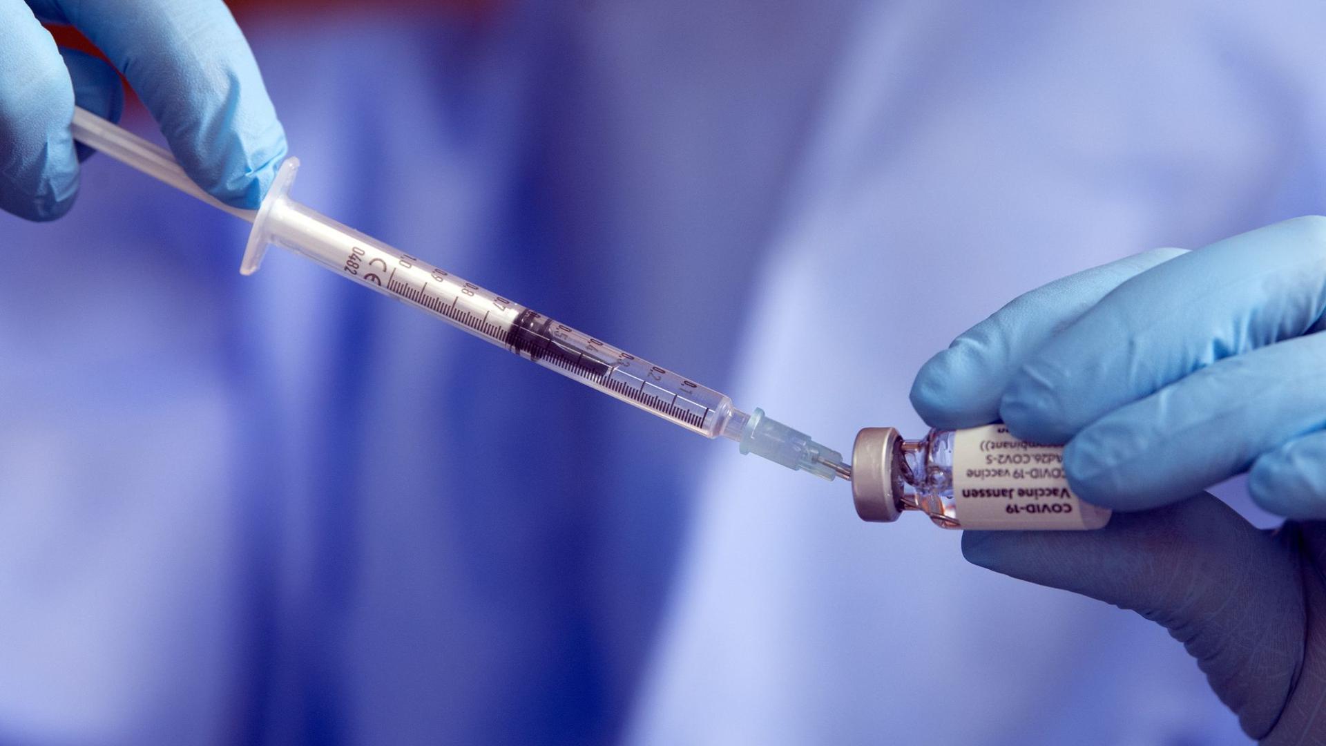 Eine Spritze mit einem Corona-Impfstoff wird aufgezogen.