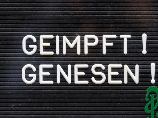 "Geimpft! Genesen!“ steht auf einem Schild an einer Bar.