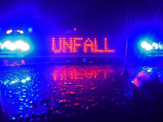 Der Schriftzug „Unfall“ leuchtet zwischen zwei Blaulichtern auf dem Dach eines Polizeiwagens.