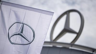 Eine Fahne mit dem Logo der Marke Mercedes-Benz weht im Wind.