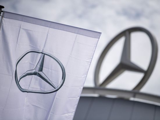 Eine Fahne mit dem Logo von Mercedes-Benz weht vor einem Showroom der Firma.