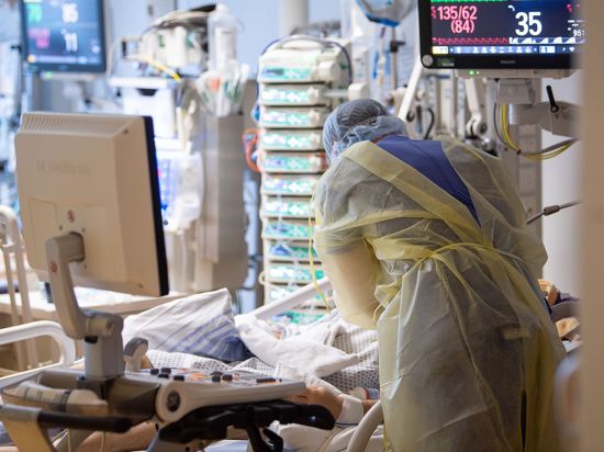 Ein Intensivpfleger arbeitet auf einer Intensivstation an einem Covid-19-Patient.