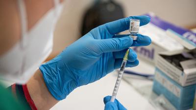 Die Mitarbeiterin eines mobilen Impfteams bereitet eine Spritze mit einem Impfstoff gegen das Coronavirus vor.