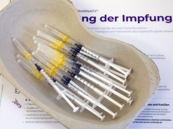 Spritzen mit dem Comirnaty-Impfstoff des Herstellers Biontech/Pfizer liegen in einer Schale.